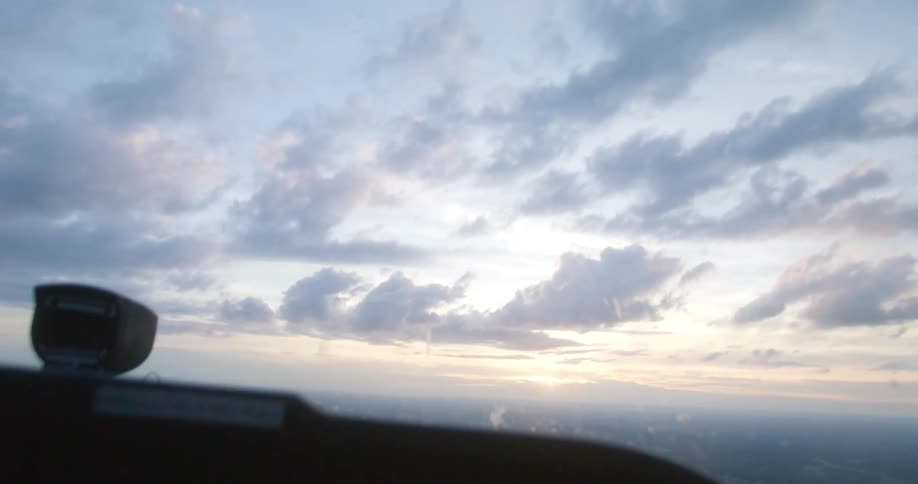 Sunset behind the clouds seen from the cockpit of a small flying plane