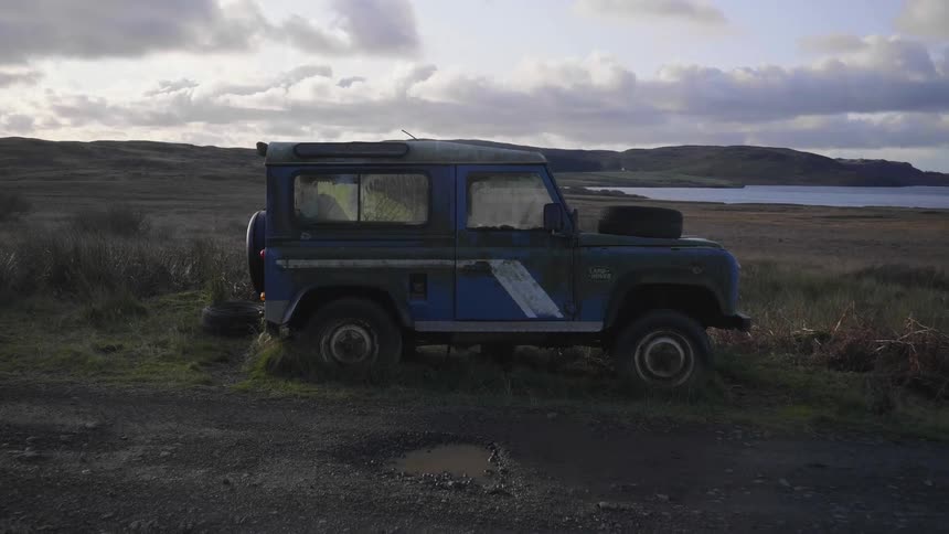 An abandoned vehicle parked in a field