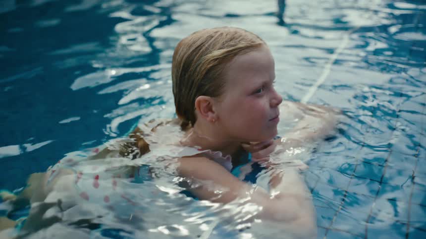 A girl swimming out in a pool on a sunny day