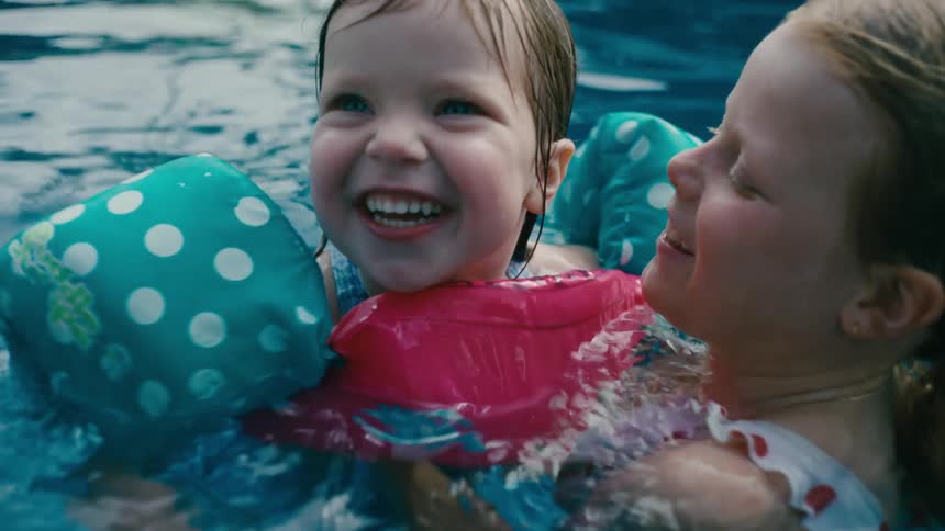 Two little girls swimming together in a pool