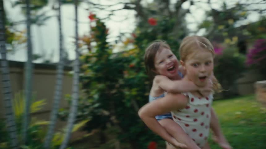 Two children running around playing outdoors