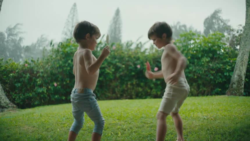 Two children dance and eat ice cream