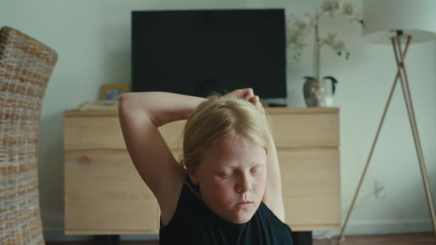 Girl doing calisthenics stretches on the living room at daytime
