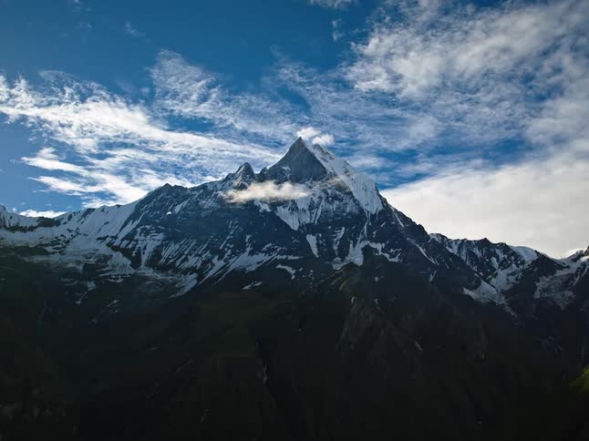 Snow covered mountain peak on a partly cloudy day