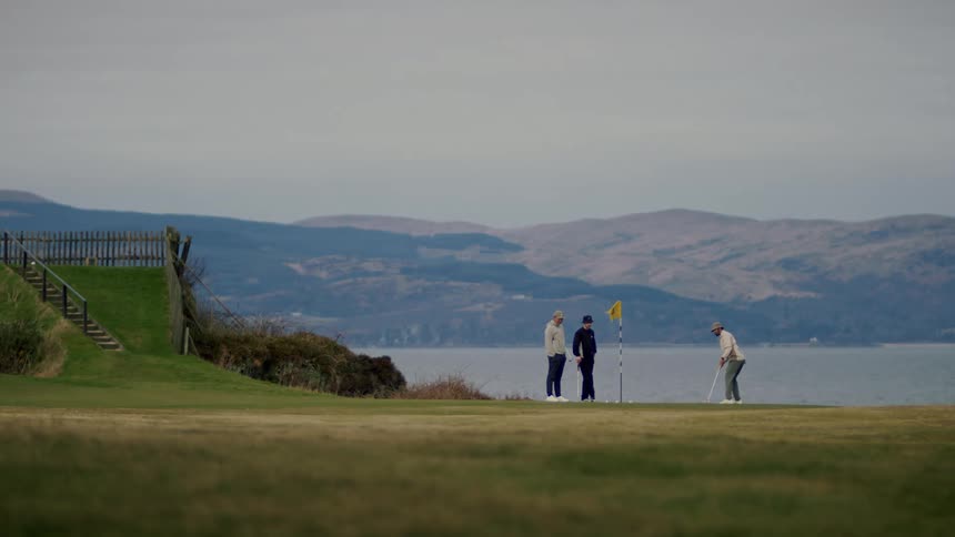 Friends playing golf on a course near the beach