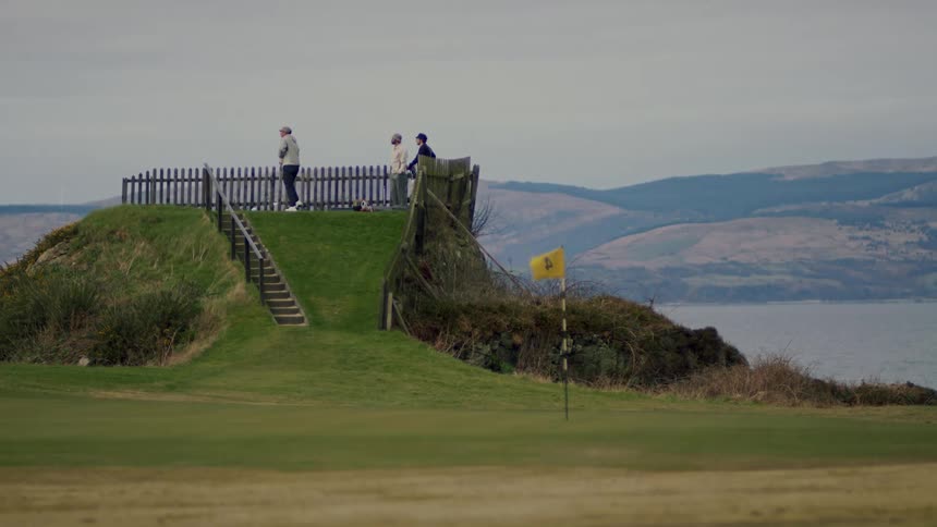 Men playing golf on a golf course next to a lake