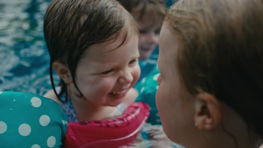 Kids playing and smimming in the pool