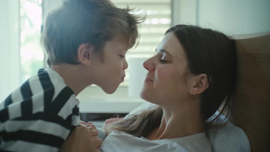 A mother getting a kiss from her son