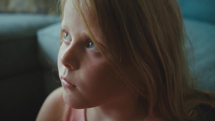 A child sitting in front of a couch in a room