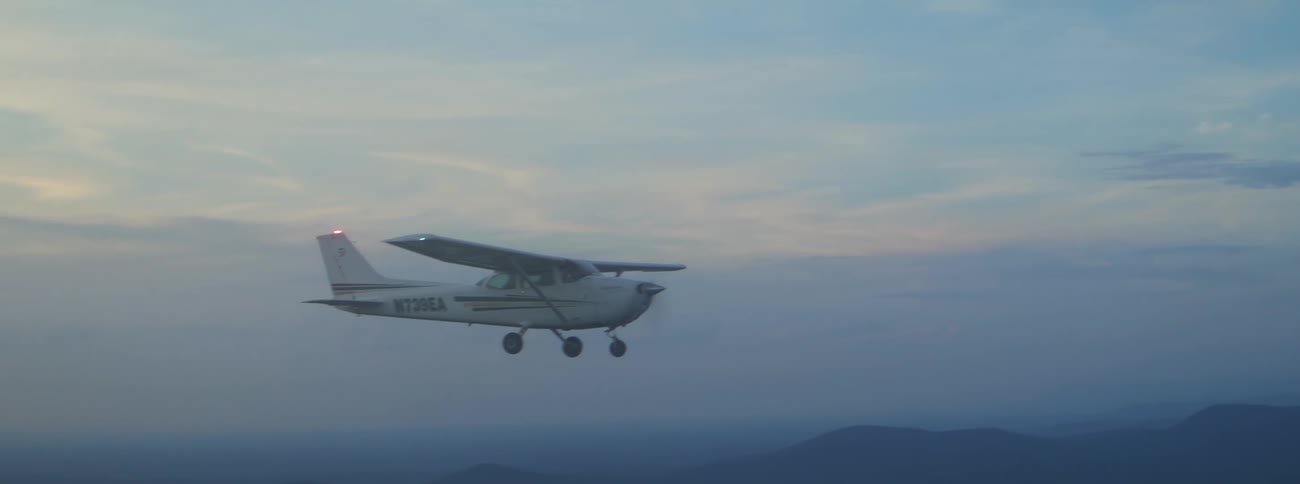 A plane flying outdoors on a cloudy day