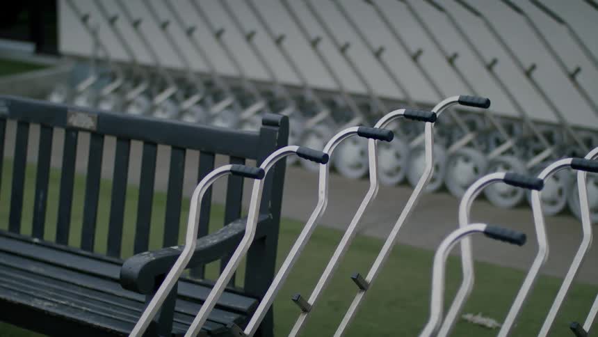 A bench and some hand carts outdoors in a park