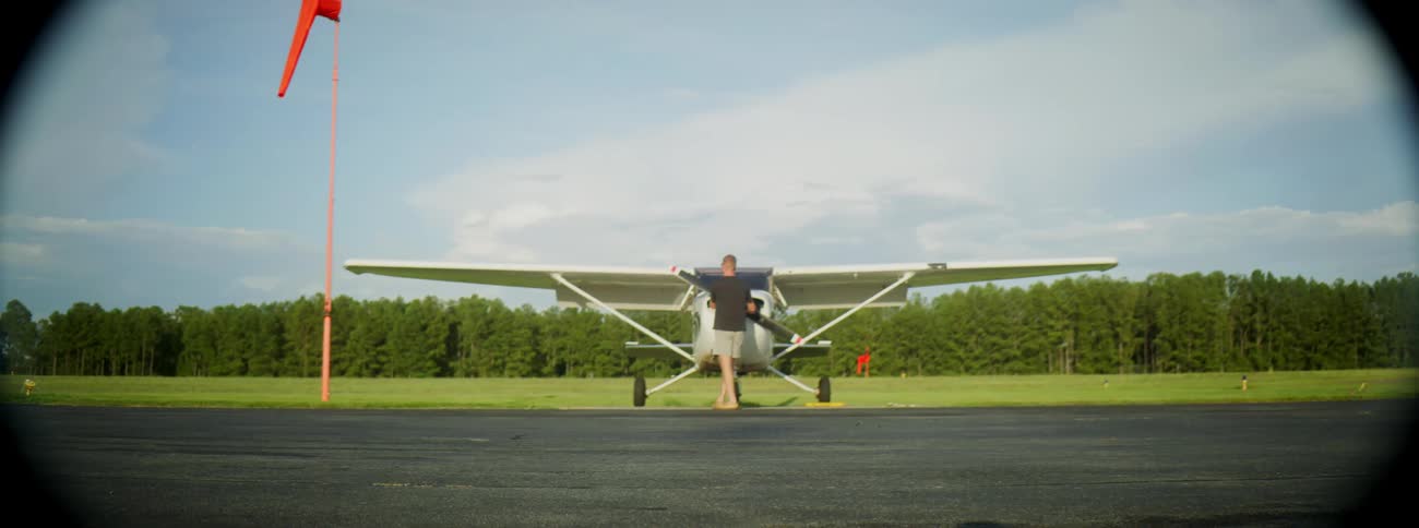 A man looking at an aircraft on an airstrip
