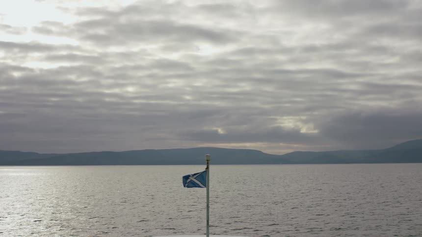 The flag blows in the wind by the lake
