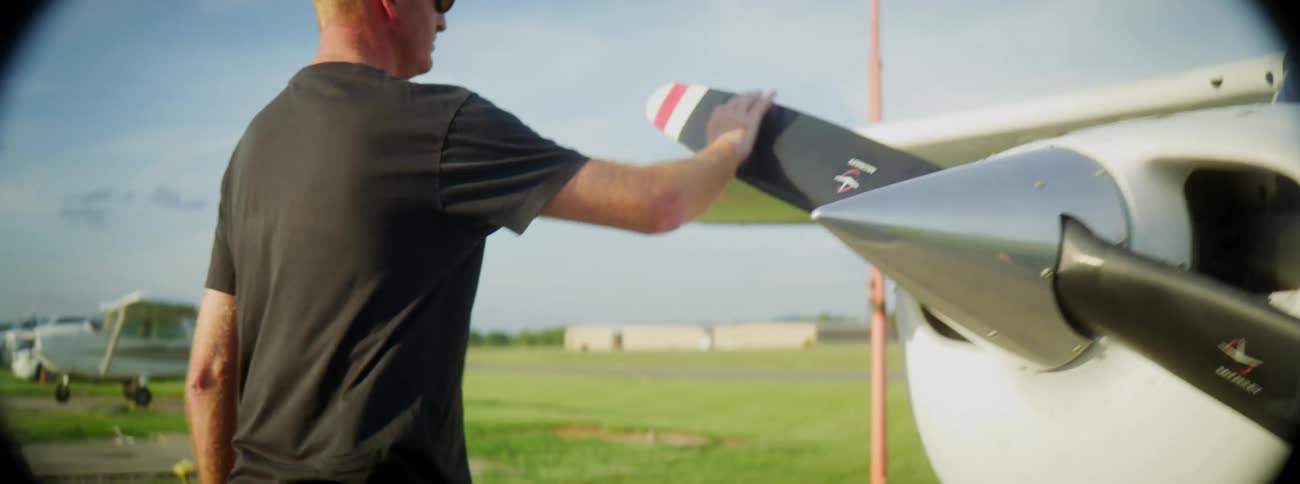 Man walks around small plane doing inspection