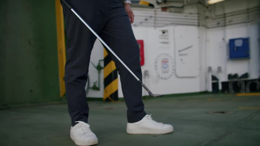 Man standing up indoors playing with a golf ball