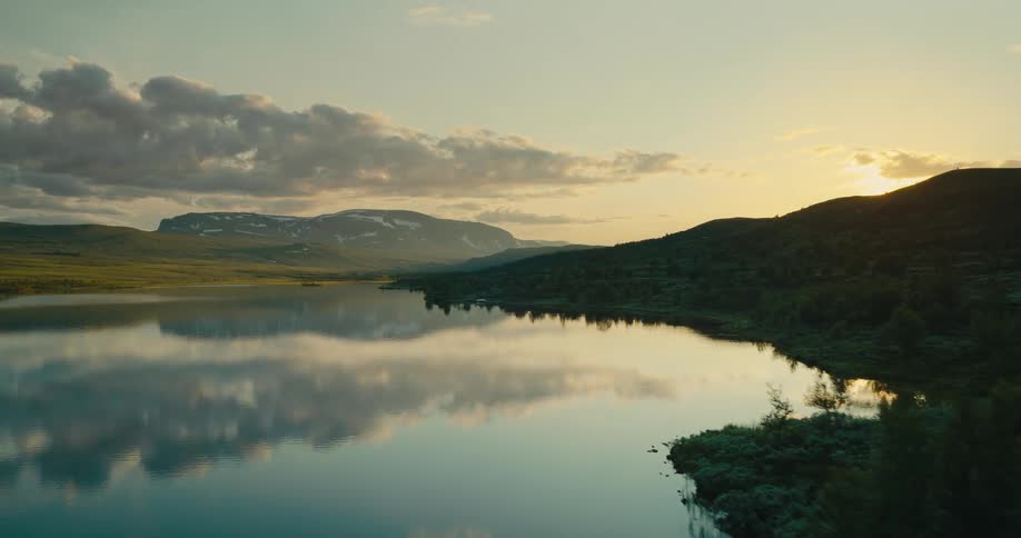 Aerial view of a lake with hills and mountains on the background during day time