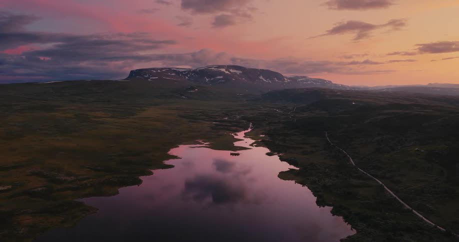 Tranquil scene of a river with mountains in the background at evening