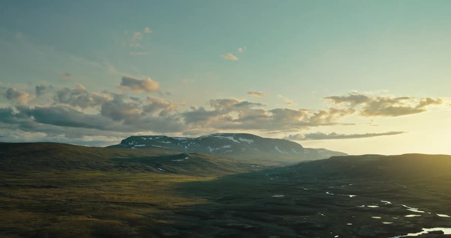 A serene scene of a river with mountains in the distance at sunset