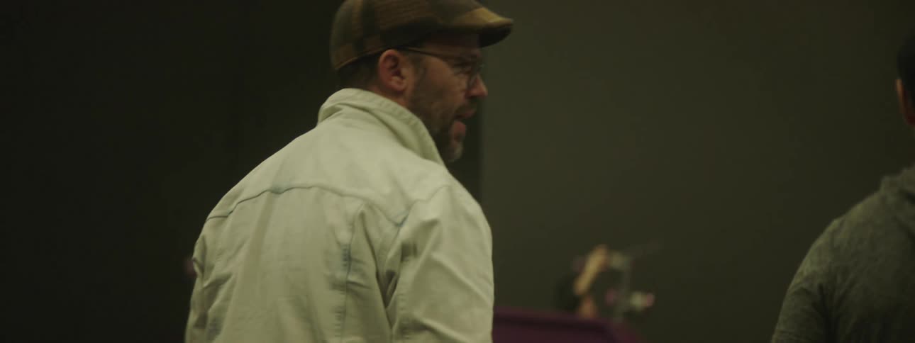 A couple of men walking inside a large studio talking