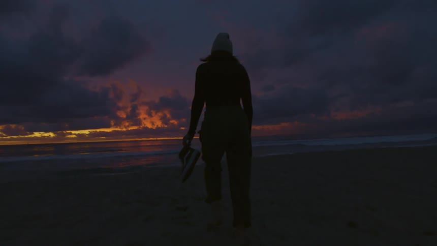 A clip of a lady walking down the beach