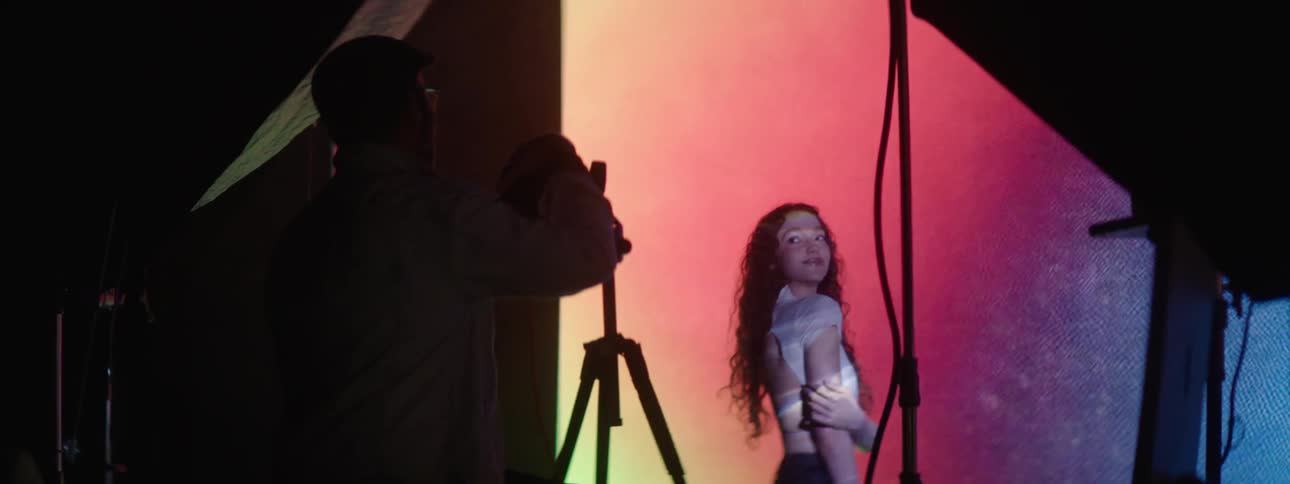 A photographer taking pictures of a model in a studio