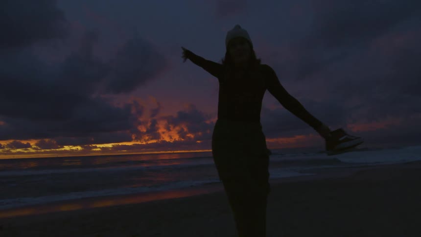 A woman is walking on the beach