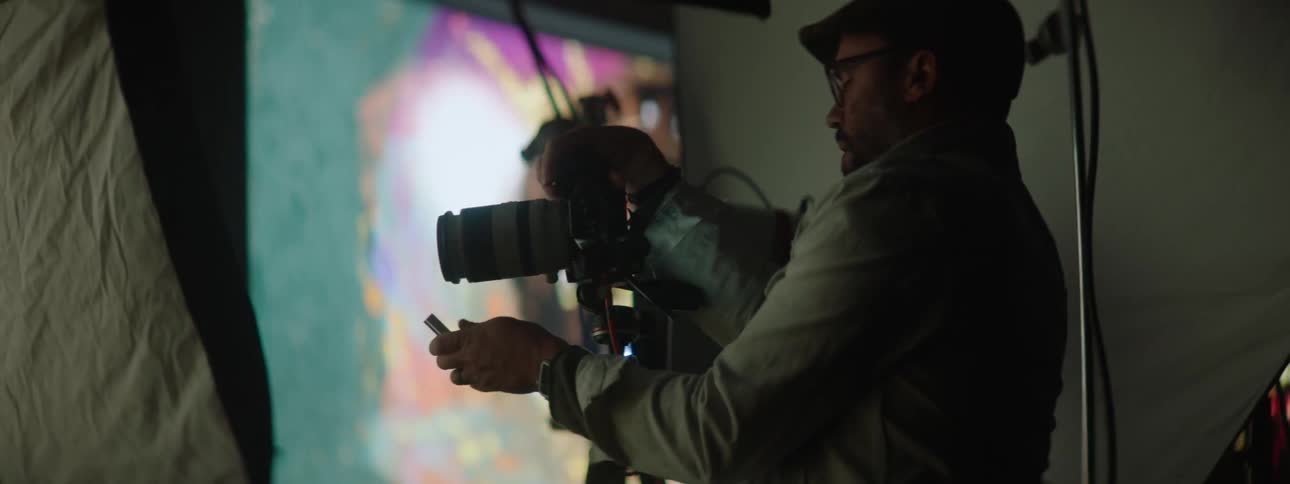 Photographer takes pictures of a model in a studio