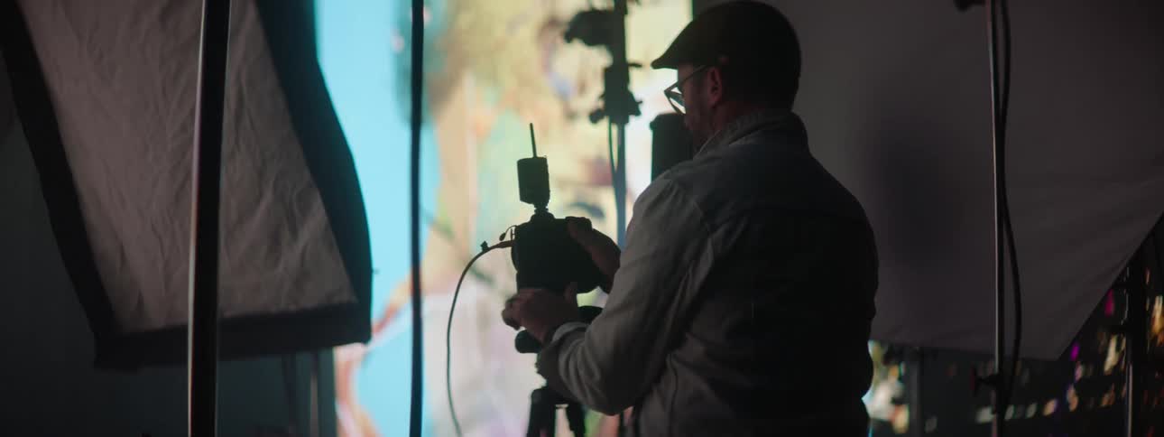 A photographer inspecting and holding his camera in a photography room