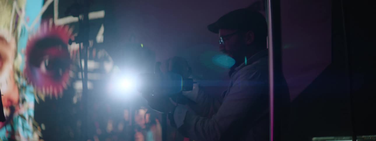 Photographer takes pictures of a model in front of a large projector in the background