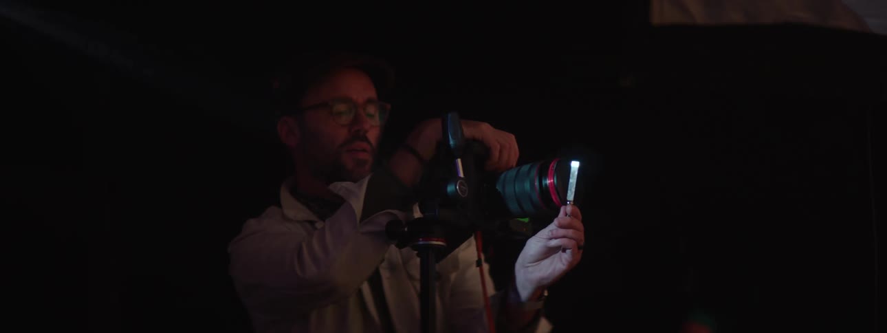 Photographer moves an object in front of the lens while taking pictures of a model