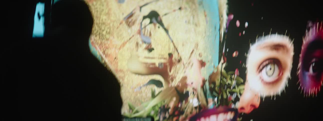 Silhouette of a man in front of a large projector