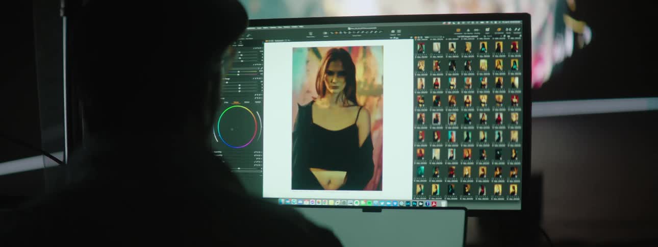 People working on a computer in a photography set with a large projector in the background