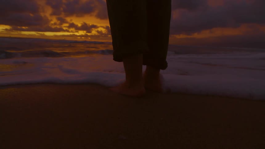 A clip of beach waves washing a persons foot