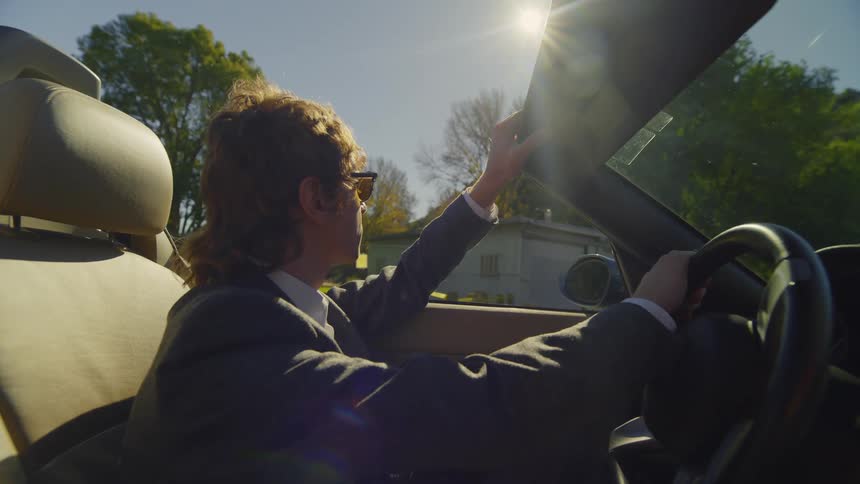 A man pulls up in front of a woman in his car