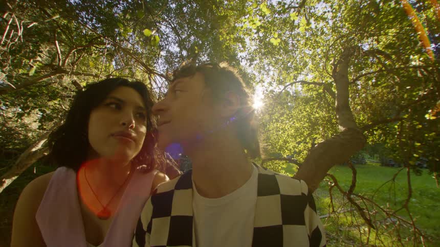 A man and woman sitting together out in a forest