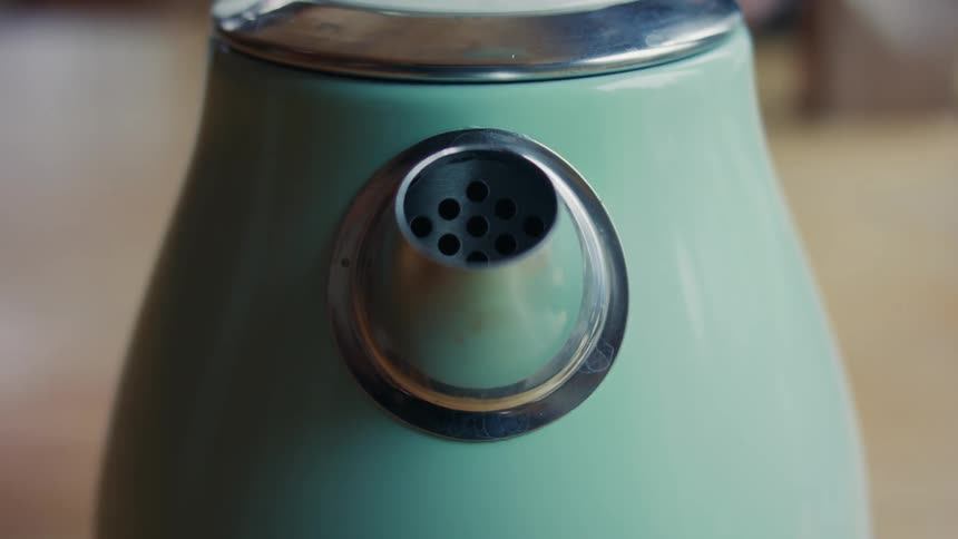 Steam escapes from the spout of a tea kettle
