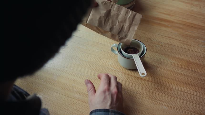 A person preparing a small cup of coffee