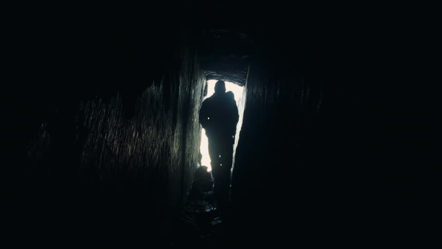 A person walking through a narrow cave