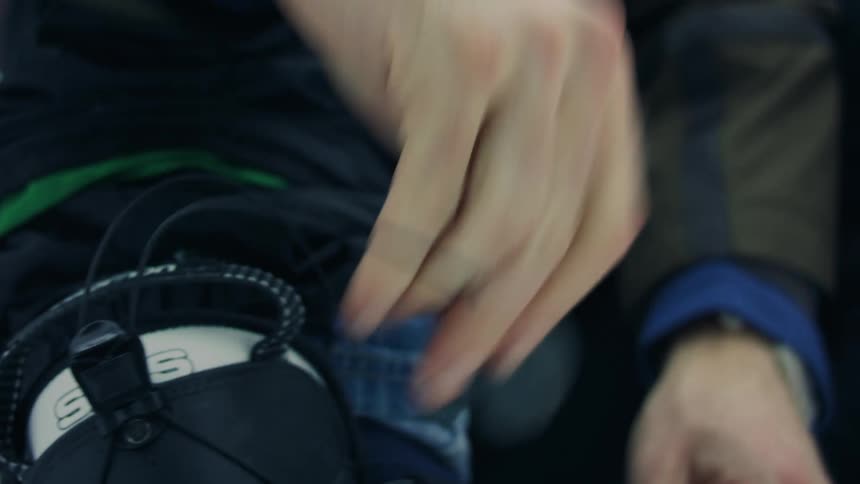 Closeup of a mans hands tying his ski boot