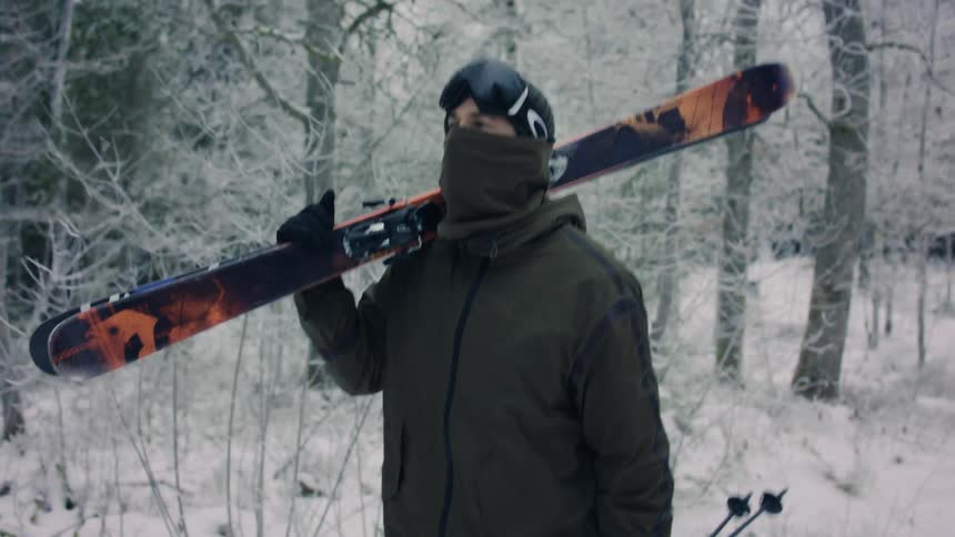 A person walking in the forest with a snowboard