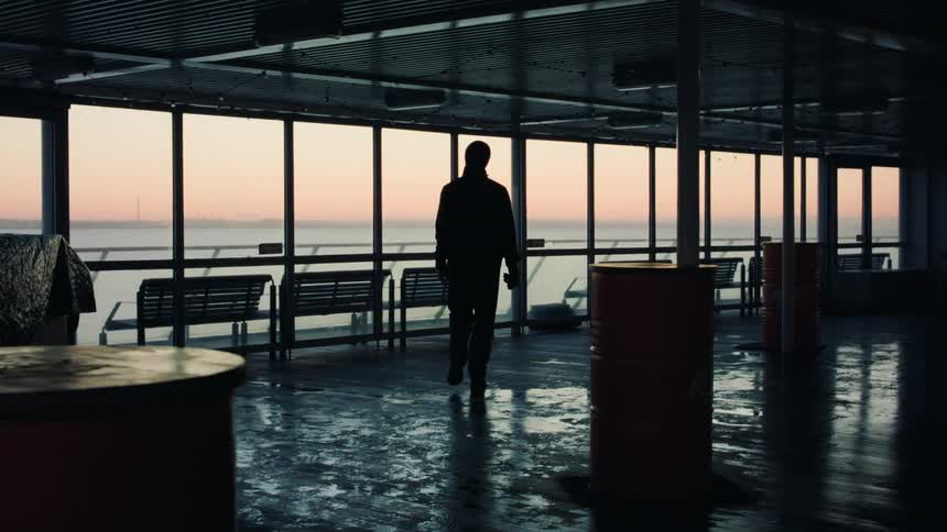 A man in an office walking up to some windows