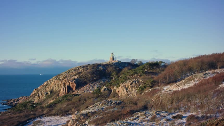 A lighthouse on top of a rocky hill