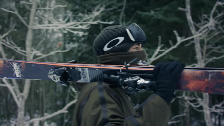 Closeup of a man walking with his ski equipment on his shoulder
