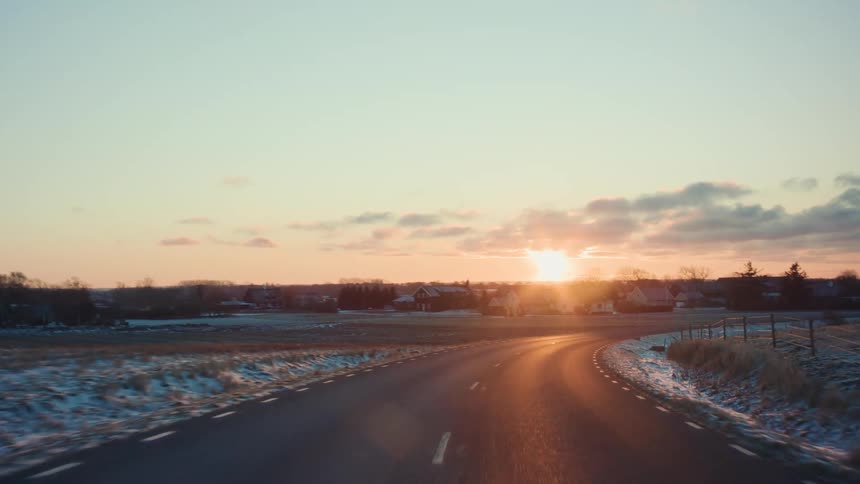 A snowcovered road in a neighborhood during the early hours of the morning