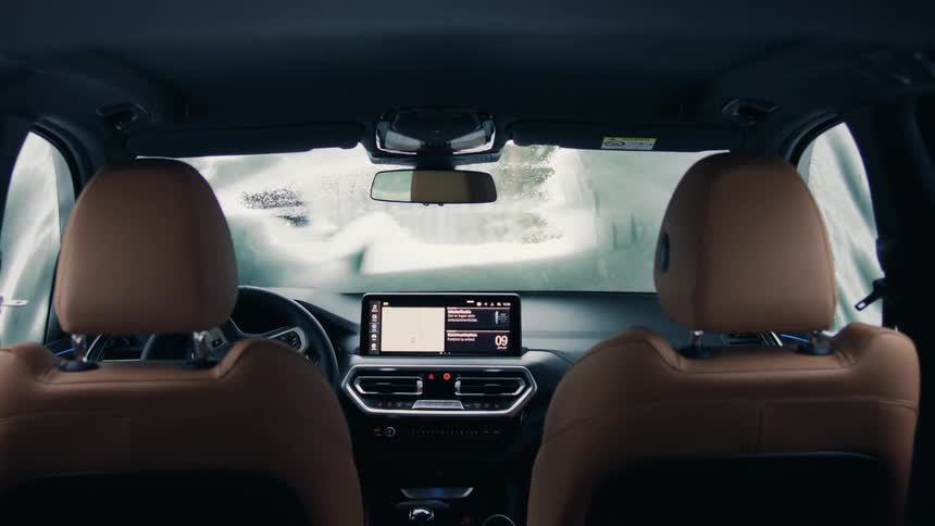 View from inside a car with a person outside cleaning the windshield