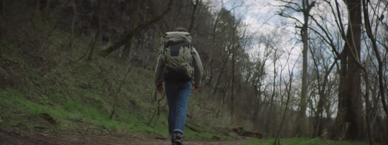 A man hiking out in a forest on a cloudy day