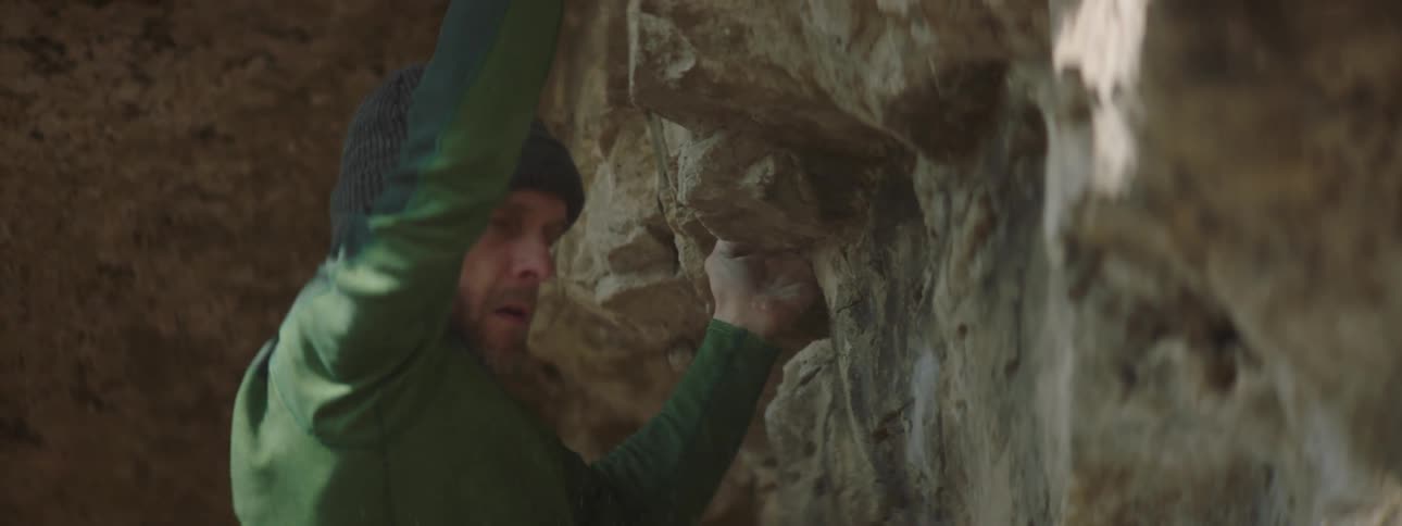 A man trying to climb a mountain during the day