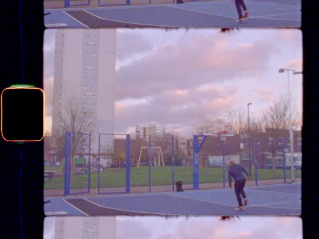 A man playing basketball on an outdoor court in the neighborhood