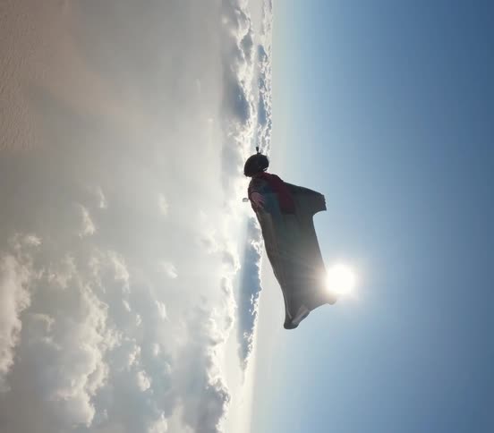 A person is practicing wingsuit and is gliding in the sky