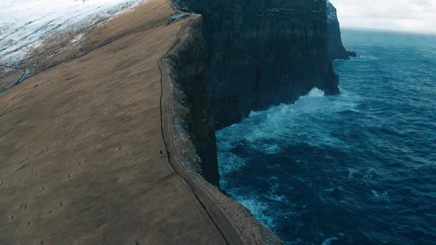 A person running on top of a mountain range on the sea coast
